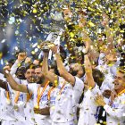 Karim Benzema (c), autor de uno de los dos tantos del equipo, levanta el trofeo de monarcas.