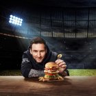 Fotografía promocional cedida por Hard Rock International donde aparece el jugador argentino de fútbol Leo Messi mientras muestra una enorme hamburguesa bautizada "Messi Burger" presentada en un pan brioche tostado con dos porciones de carne, además de queso provolone, chorizo en rodajas, cebolla roja caramelizada, lechuga romana y rodajas de tomate, todo ello aderezado con una salsa picante y ahumada.
