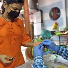 Un sanitario toma una muestra de sangre a una joven para detectar malaria y dengue en Mumbai / El País