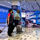 Espera. Dos personas pasan frente a un mostrador de Interjet en el aeropuerto de Ciudad de México. Miles llevan un año sin volar en esta aerolínea.