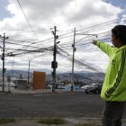 Las Casas. Erick Zumba señala la cantidad de cables que están desordenados en un poste en este sector.