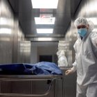 Personal de salud traslada a un paciente fallecido por la covid-19