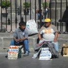 Dos personas buscando que los contraten para una construcción.