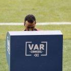 Wimar Roldán observa el VAR para cambiar la expulsión del arquero brasileño Alisson por una amonestación.