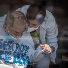 Un sanitario con mascarilla sostiene la mano de un residente de una casa de Alzheimer en Pitkovice,