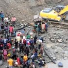 Cientos de personas y maquinaria pesada extraen oro durante el día.