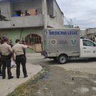 Policías rodean el cuerpo de la víctima que ha sido cubierto con una sábana.