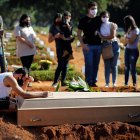 Fotografía de archivo en al que se registró a una familia durante el entierro de un familiar víctima de la covid-19, en el cementerio Vila Formosa, en Sao Paulo (Brasil).