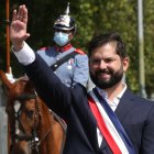 El presidente de Chile, Gabriel Boric, saluda a bordo del vehículo presidencial Ford Galaxie donado por la reina Isabel II de Ingalterra.
