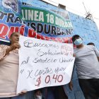 Una comitiva de los transportistas acudió al sitio donde se ejecutó la reunión. Ellos pedían, con carteles, el alza al pasaje.