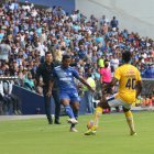 Romario Caicedo, jugador de Emelec, domina el balón mientras Ismael Rescalvo, entrenador azul, sigue la acción.