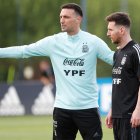 El jugador Lionel Messi (d) escucha instrucciones del entrenador Lionel Scaloni, en una fotografía de archivo.