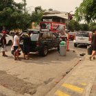 Las personas se aglomeran cerca de los vehículos en la calle Ayacucho