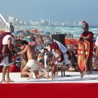 Fieles representan el viacrucis durante la celebración del Viernes Santo en una playa de Cancún (México).