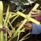 Una mujer compra una cruz de palma de cera, en una fotografía de archivo