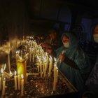Personas encienden velas en la madrugada de hoy tras realizar la "Caminata de la Fe", desde la ciudad de Ambato hacia Baños de Agua Santa, en la provincia de Tungurahua (Ecuador).