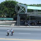 Peatón. Dos mujeres cruzan casi corriendo la vía, ante el deterioro del paso peatonal del sector donde ocurrió un accidente.