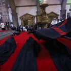 La bandera negra con una cruz roja es ondeada a los ocho canónigos postrados en el suelo.
