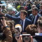 El presidente francés y candidato a la reelección Emmanuel Macron (c) saluda a la gente antes de acudir al colegio electoral en la segunda vuelta de las elecciones presidenciales francesas