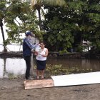 Brigada. Un funcionario del Municipio de Samborondón entrega una ración alimenticia a una habitante de un recinto de esa jurisdicción.