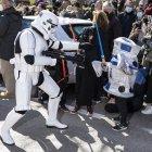 Un soldado de asalto imperial de la saga cinematográfica Star Wars se acerca a dos niños disfrazados mientras participan en el desfile del Galaxy Day, el domingo por una calle de Madrid.