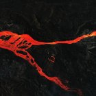 Imagen de archivo tomada con un dron de una colada de magma que discurre hacia el mar rodeada de roca volcánica por la erupción del volcán Cumbre Vieja.