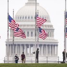 Funcionarios de Parques Nacionales ondean las banderas a media asta, este 12 de mayo de 2022 en Washington, para recordar a los fallecidos por covid-19, que superan el millón de personas en el país