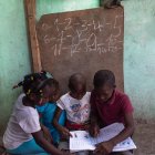 Niños le enseñan hoy a niños de menor edad en un albergue de desplazados internos por la guerra de pandillas, en la comuna de Tabarre, distrito de Puerto Príncipe (Haití).