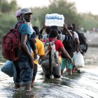 Migrantes procedentes de Haití cruzan el Río Bravo hoy, en Ciudad Acuña, en Coahuila (México). Mas de 10,000 migrantes han llegado en los últimos días a las ciudades fronterizas de Del Rio Texas en Estados Unidos y Ciudad Acuña en México y esperan bajo el puente Internacional que la solicitud de asilo sea procesada por las autoridades de Estados Unidos. EFE/Miguel Sierra ag-periodistas