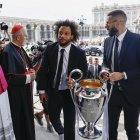 Los capitanes del Real Madrid Marcelo (i) y Karim Benzema (d) son recibidos por el arzobispo de Madrid, Carlos Osoro (2i), a su llegada a la Catedral de la Almudena, una de las paradas del recorrido realizado esta tarde por el equipo para celebrar su victoria en la final de la Liga de Campeones.