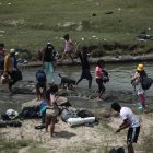 Un grupo de venezolanos atraviesan un riachuelo en la frontera entre Ecuador y Perú.