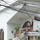 Marisol Paredes, quien reside en la manzana 207 de Guayacanes, muestra a EXPRESO la hilera de cables que cruzan el balcón de  su casa. Muchos de ellos no tienen ninguna función, pero nadie los ha ido a retirar.