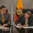 Francisco Cepeda, presidente del Consejo Directivo del IESS, y el ministro de Finanzas, Simón Cueva, durante el pago de parte de la deuda por salud.