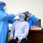 Un sanitario realizando una prueba PCR en Hanói