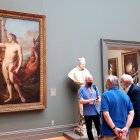 Unas personas observan la obra "Marcantonio Pasqualini coronado por Apolo", pintada en 1641 por el artista italiano Andrea Sacchi, el 16 de junio de 2022, en el Metropolitan Museum, en Nueva York (Estados Unidos)