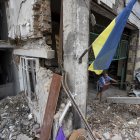 Empleados trabajan en recoger los escombros del taller que fue atacado hace dos días por un misil ruso, este jueves en Dnipro (Ucrania).