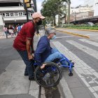 Aquiles Valarezo tuvo que pedir ayuda para cruzar de una acera a otra en el centro de la urbe, pues su silla de ruedas se quedó atorada en un hueco entre la rampa y la calzada.