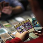Dos jóvenes juegan cartas de la serie manga Yu-Gi-Oh!