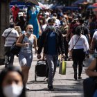 Un hombre carga una bolsa de comercio por una calle del centro de Santiago (Chile)