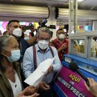 El ministro José Ruales acompaña a la usuaria Bélgica Vera a retirar sus medicinas en una farmacia.