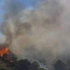 Un helicóptero del servicio de bomberos trabaja en el incendio declarado en la sierra de Mijas, Málaga, este sábado.
