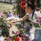 Fotografía de archivo, tomada el pasado 29 de mayo, en la que se registró a una mujer al hacer una ofrenda floral frente a la institución académica Robb Elementary School, en Uvalde (Texas, EE.UU.), luego de que un joven desadaptado asesinara a 19 niños y dos maestras e hiriera a otras 17 personas.