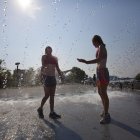 Personas se refrescan en una fuente ante las temperaturas registradas durante una ola de calor