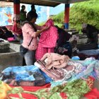 Las mujeres clasifican la ropa por el tipo de tela y color para lavarla por separado.