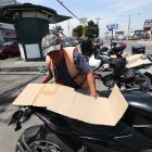 Motos. En días con sol, Freddy Mazón recurre a cartones para colocar sobre los asientos de las motos que cuida. Así se gana más ‘voluntad’ de quienes confían en su labor.