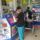 Segundo Luna, de 70 años, retira su insulina en la farmacia ubicada frente al Hospital Abel Gilbert, en el suroeste de la ciudad. Al fondo, un familiar hace lo mismo con los fármacos de un persona con movilidad reducida.