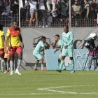 Danny Luna festeja el tanto albo con Alexander Alvarado, mientras los jugadores de Aucas se lamentan.