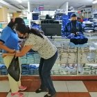 Tienda.- Madre de familia compra ropa para su hija.