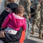 Una mujer afgana y su hijo acuden a un punto de recogida antes de partir hacia EE.UU.