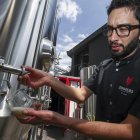 El gerente de producción de Sinners Micro Cervecería, Andrés Bermeo, sirve una muestra de la cerveza el 19 de agosto de 2022 en Quito (Ecuador).